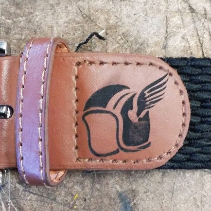 Primer plano de hebilla de cinturón con un grabado en la piel