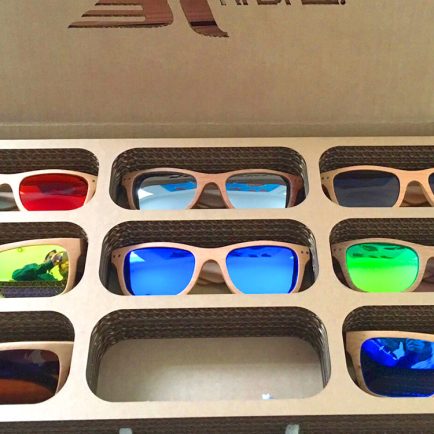 Bandeja expositor fabricada en cartón con gafas de sol en huecos recortados
